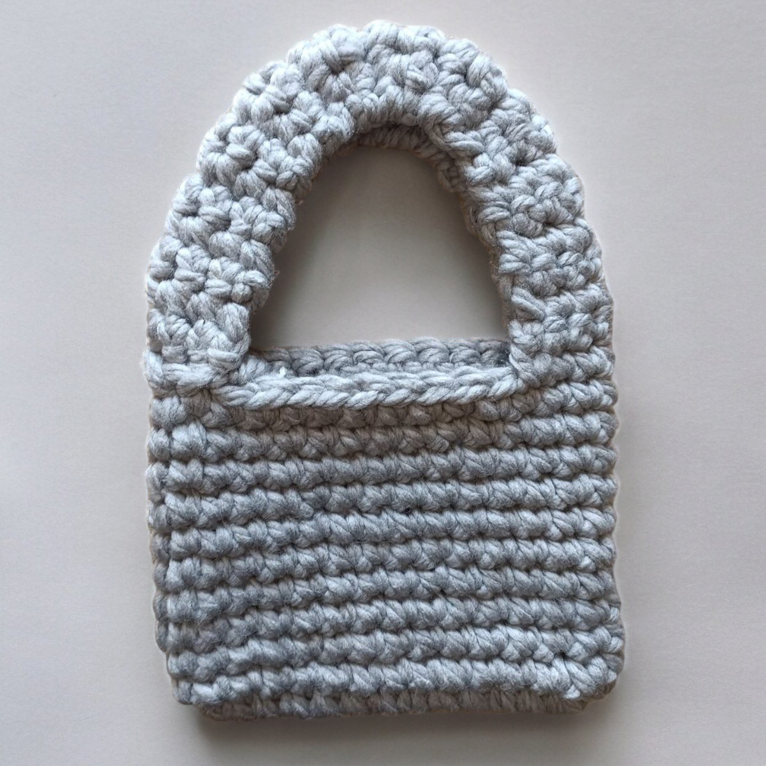 Crocheted gray bag on a white background