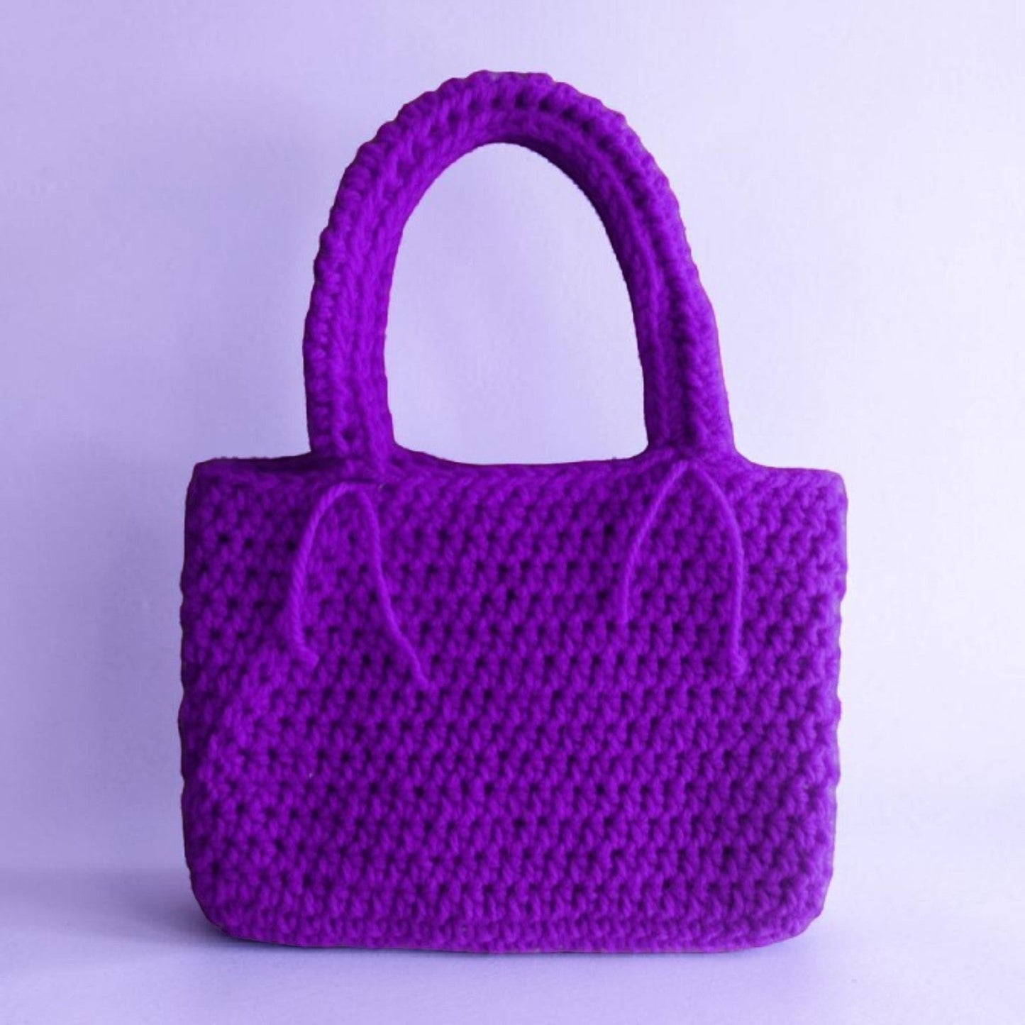 Purple crocheted handbag on a light purple background