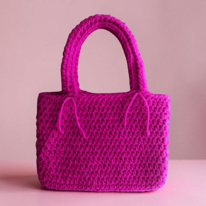 Pink crocheted handbag on a pink background